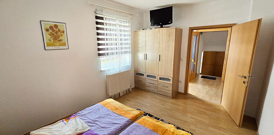 Schlafzimmer mit Schrank und TV in der Ferienwohnung 1