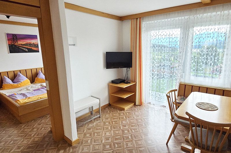 Blick ins Schlafzimmer und auf den Essbereich mit Ausgang auf den Balkon in der Ferienwohnung 3 Skant Turnersee